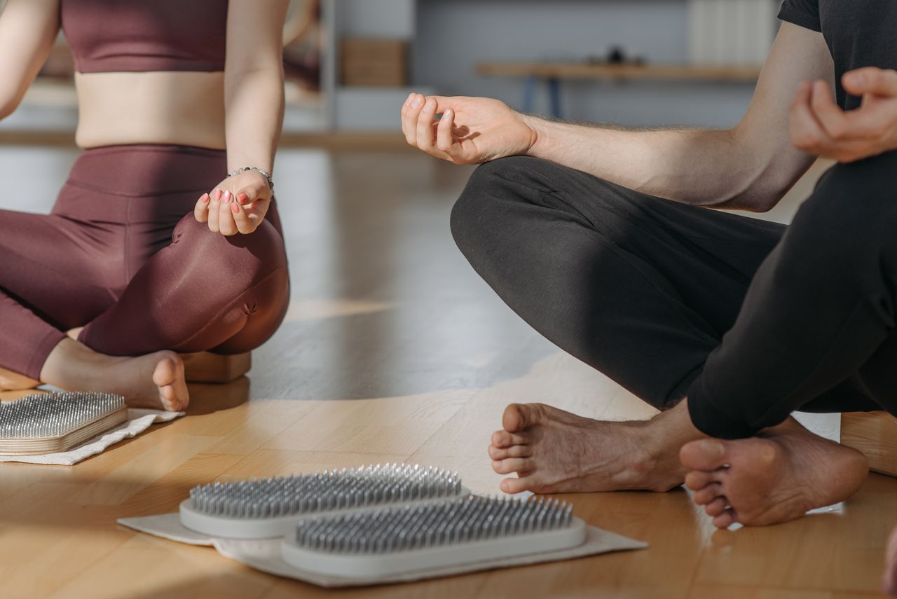 about-us A close-up of people meditating on sadhu boards, promoting relaxation and wellness.