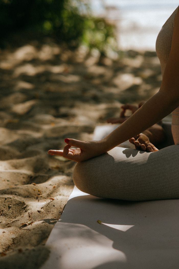 why-choose-us A peaceful scene of meditative yoga practice on a sandy beach.